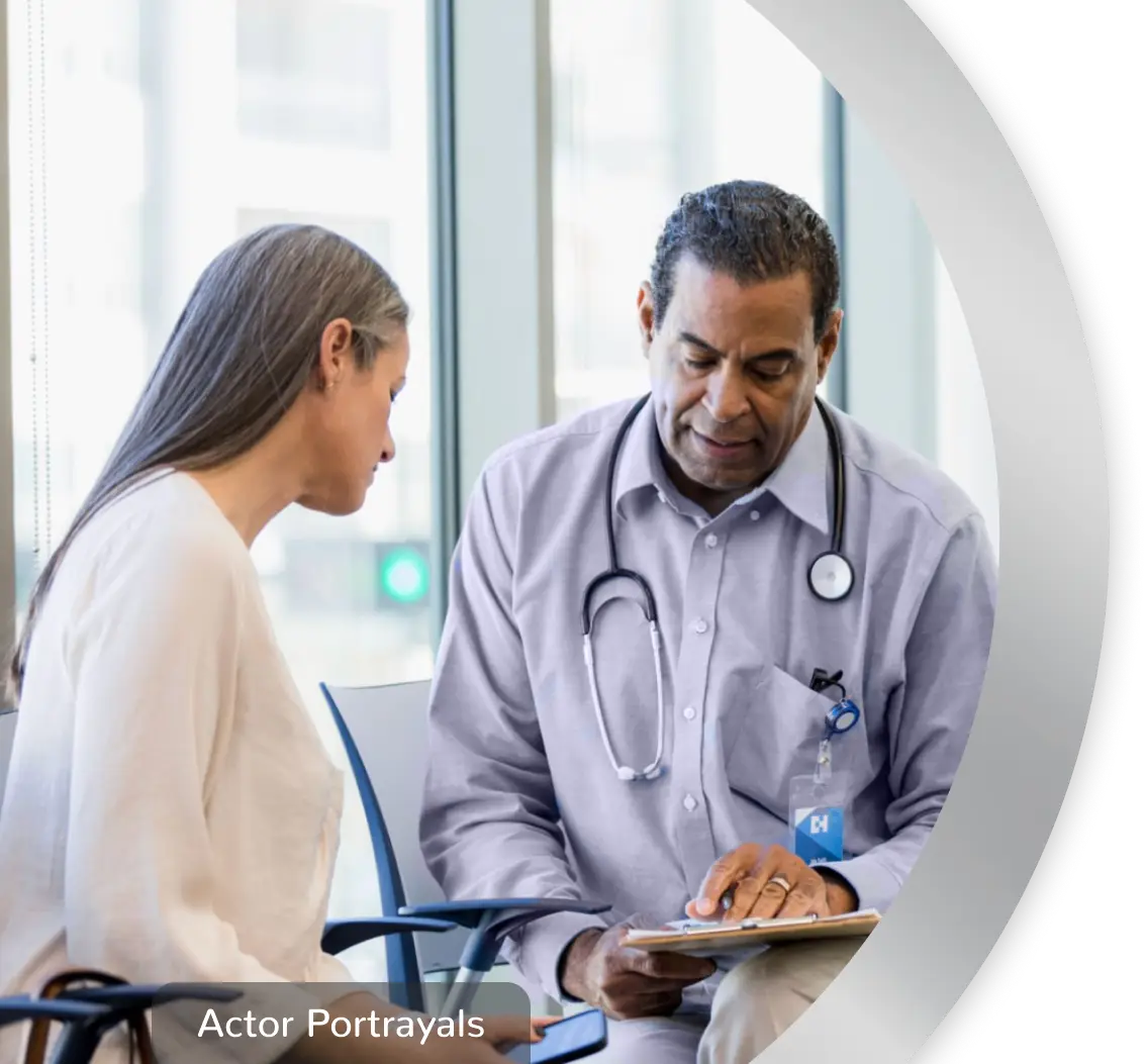 A woman sitting with a healthcare professional, while they look at a clipboard together. Actor portrayals