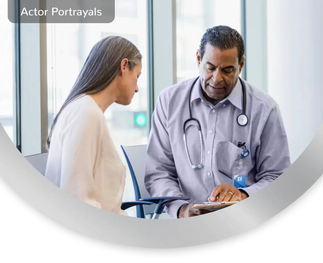 A woman sitting with a healthcare professional, while they look at a clipboard together. Actor portrayals
