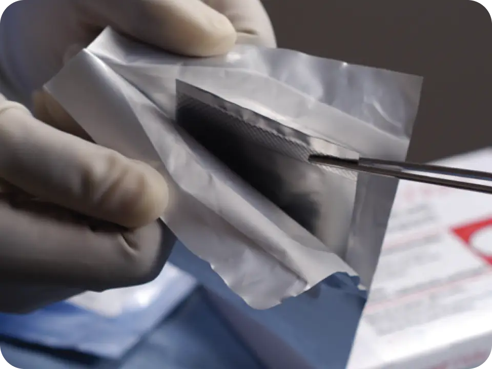Pouch being held open so that an inner pouch can be removed with a sterile instrument.