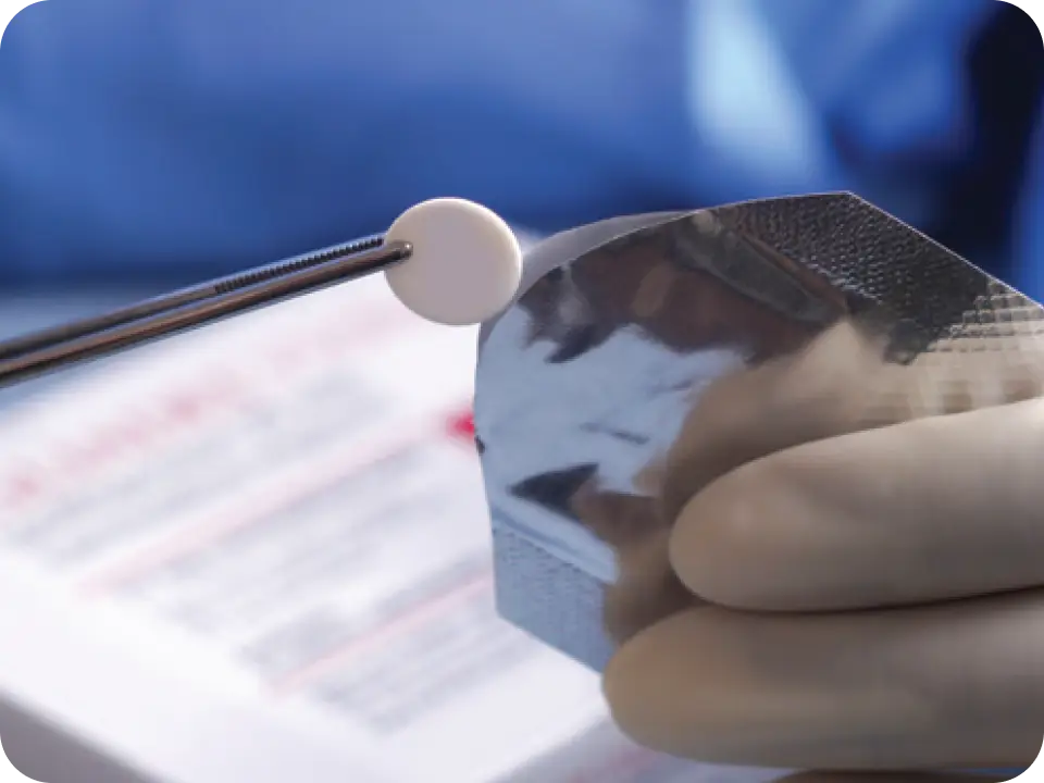 Gliadel Wafer being removed from pouch with forceps.